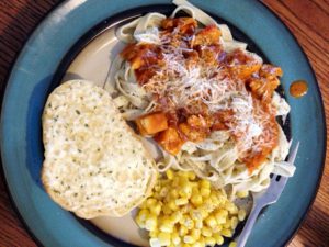 Pasta dinner with garlic bread and corn