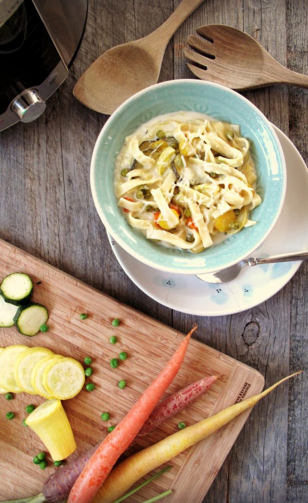 Creamy pasta with zucchini, carrots, and peas